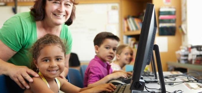 teacher leaning over student at computer