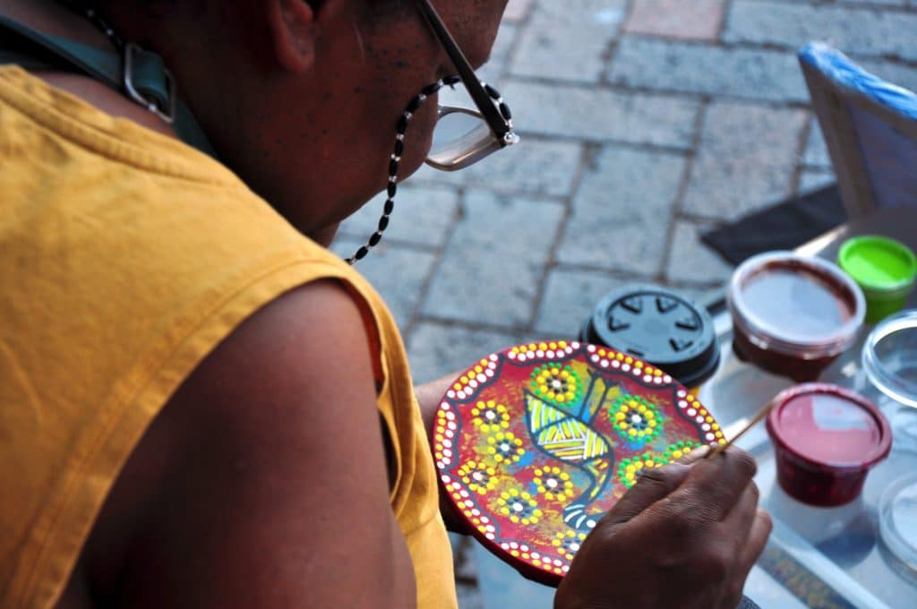 aboriginal woman doing dot painting