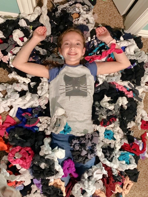 girl surrounded by sock toys