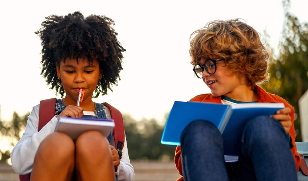 girl and boy talking while holding books